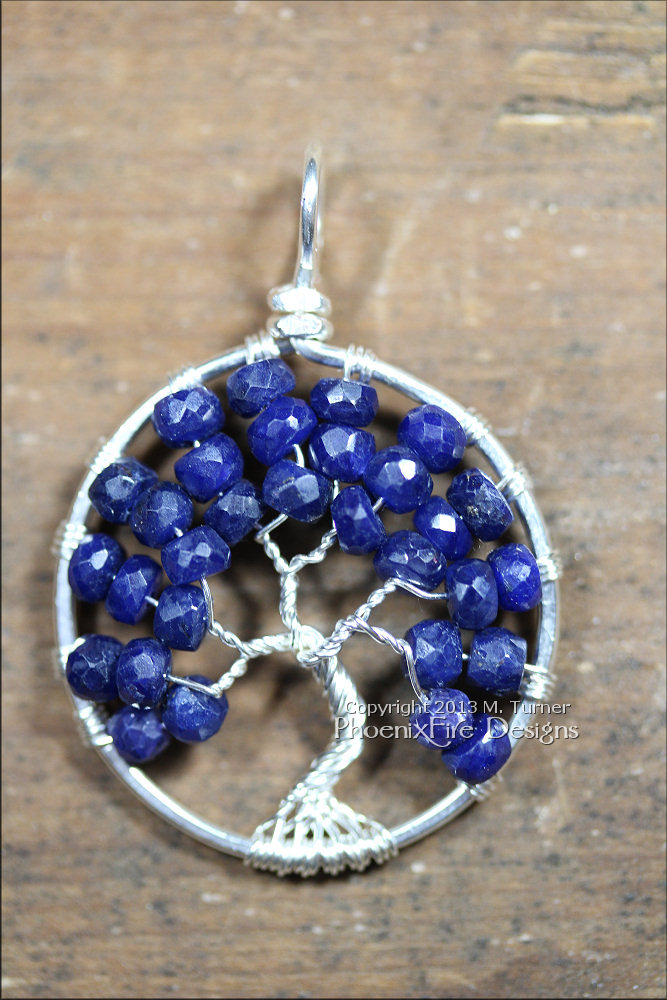 Stunning blue sapphire micro-faceted rondelles are set in sterling silver wire to form a beautiful Tree of Life pendant. Precious sapphire is the birthstone of September.