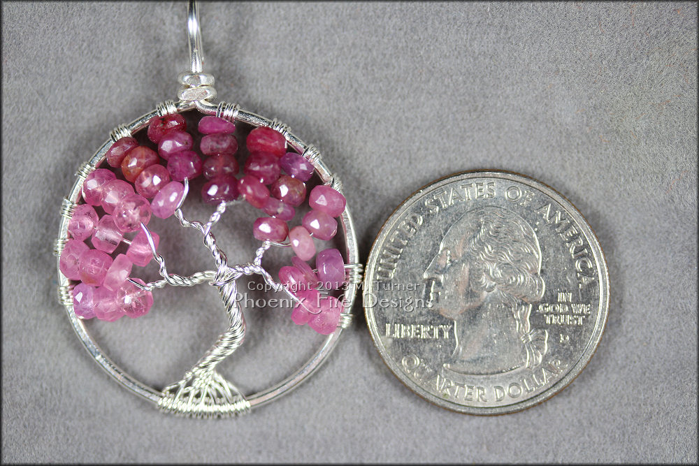 Stunning shaded ombre red, raspberry and pink ruby rondelles in silver wire make up this Tree of Life Pendant featuring July's precious gemstone birthstone.