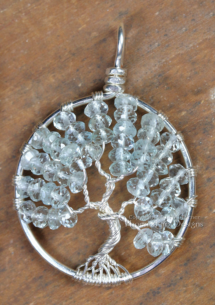 Tree of Life Pendant in striking pale blue faceted aquamarine rondelles wire wrapped in non-tarnish silver wire forming a handmade pendant in the icy birthstone of March. Handmade by Miss M Turner of PhoenixFire Deisgns on etsy.