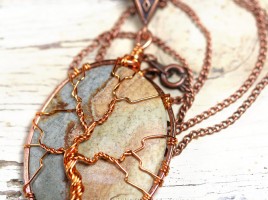 A multicolor cabochon agate is encircled in copper and a tree of life pendant is wire wrapped on the surface forming this beautiful, natural necklace. On 18" chain.